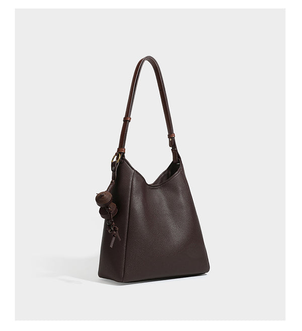 Hobo-Schultertasche in dunklem Espresso mit genarbter Oberfläche, warmen cognacfarbenen Details, verstellbarem schmalem Riemen, goldfarbenen Ringbeschlägen und geknotetem