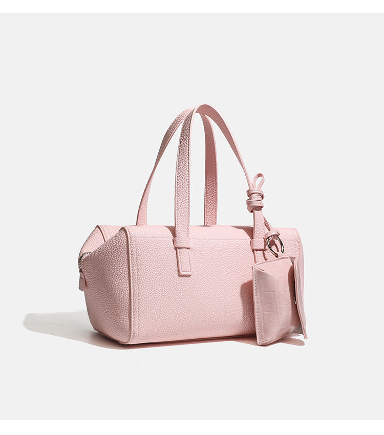 Structured pebbled leather-look top-zip barrel bag with dual handles, detachable shoulder strap, and attached croc-pattern