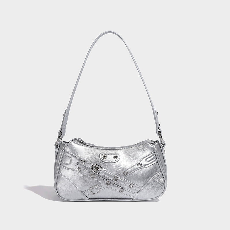 Compact moto-inspired shoulder bag with crisscross grommet strap detail, glossy textured finish, and adjustable crossbody