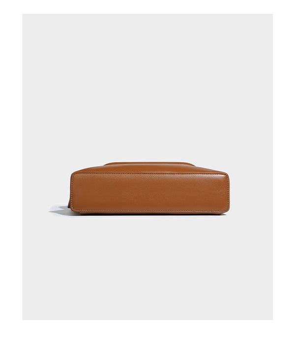 Compact structured baguette shoulder bag with smooth leather-look finish, zip top, and adjustable silver-buckle strap, detail