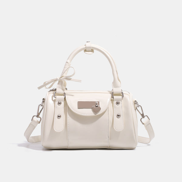 Kleine strukturierte Henkeltasche mit glänzender Oberfläche, zwei Tragegriffen, aufgesetzter Fronttasche, herzförmigem Verschlussanhänger und silberfarbenem