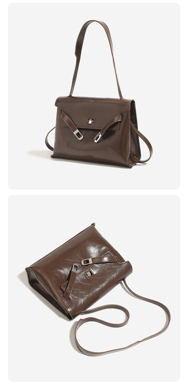 Structured trapezoidal flap satchel bag with silver-tone turn-lock clasp, decorative front strap tabs, gusseted sides, and