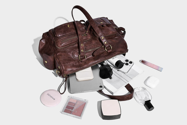 Distressed leather-look vintage satchel shoulder bag with multiple front zip pockets, dual top handles, and brass-tone