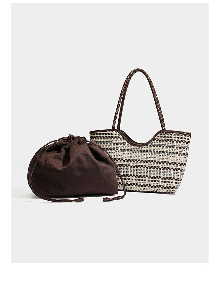 Large woven checker-pattern tote bag with dark braided shoulder straps, leather-look trim, and drawstring side ties, detail