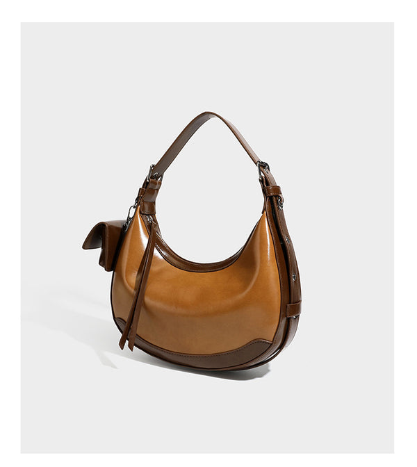 Glossy leather-look crescent hobo shoulder bag with dark contrast trim, silver-tone hardware, and attached mini flap pouch