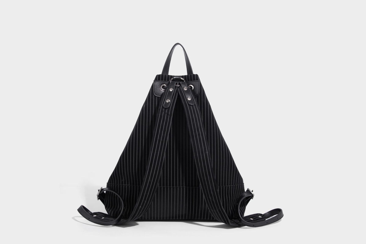 Schwarze wandelbare Rucksack-Handtasche mit Nadelstreifen, Kordelzugverschluss, Tragegriff aus Lederimitat und matten Metallbeschlägen, Detailansicht