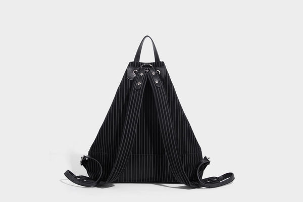 Schwarze wandelbare Rucksack-Handtasche mit Nadelstreifen, Kordelzugverschluss, Tragegriff aus Lederimitat und matten Metallbeschlägen, Detailansicht