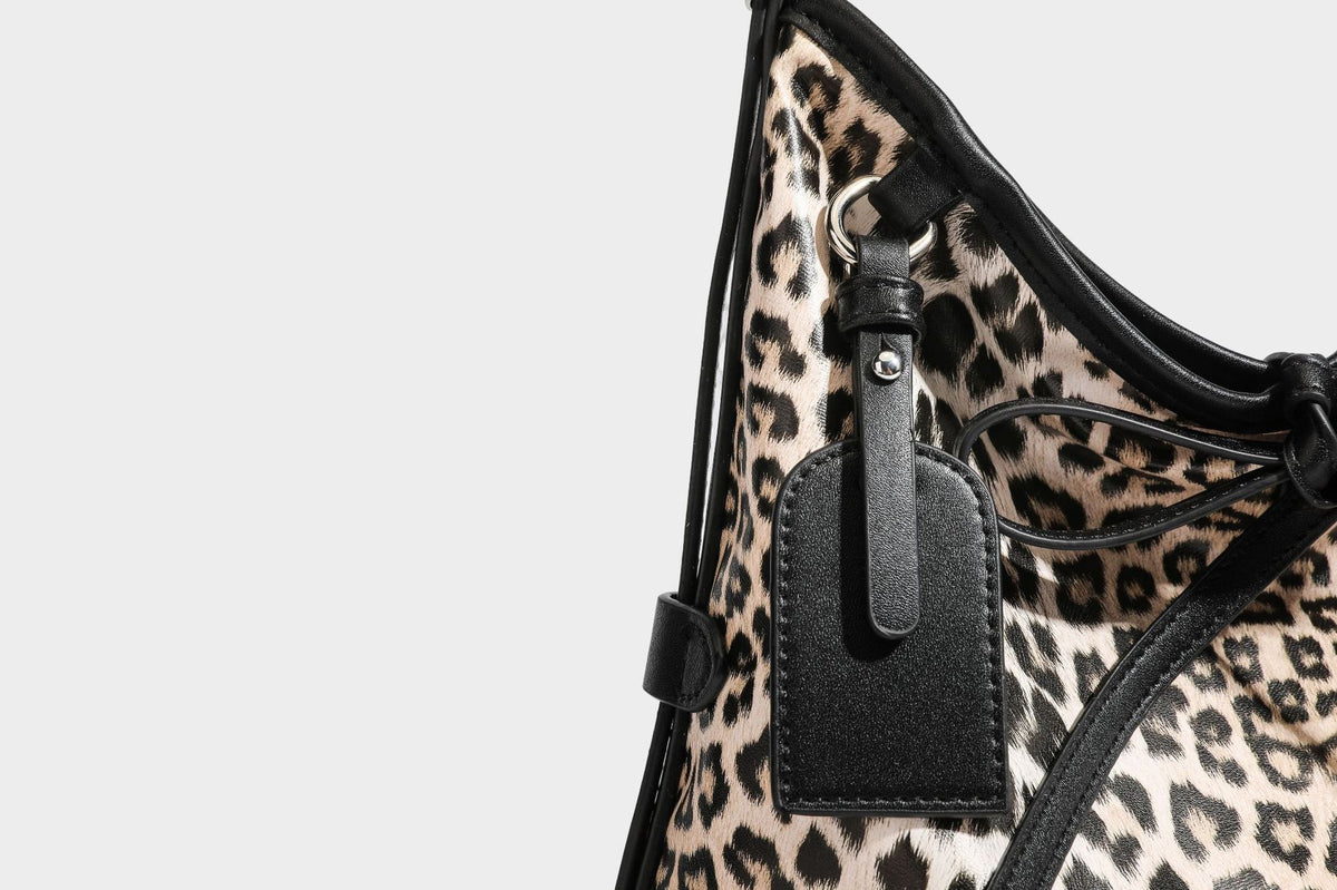 Slouchy leopard print shoulder hobo bag with black leather-look trim, tie-top closure, and single long strap, detail view 33
