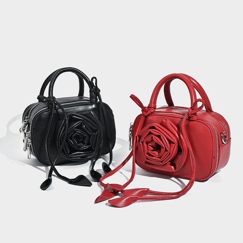 compact barrel bag with 3D rose appliqué, dual zip top, knotted handle, and adjustable crossbody strap, detail view 2