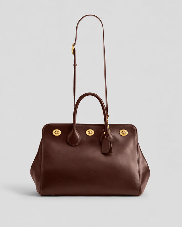 Structured leather-look tote bag with three gold-tone turn-lock closures and double rolled top handles, detail view 15