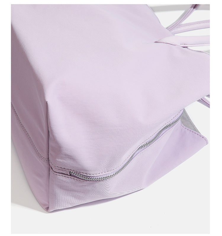 Large soft nylon tote bag with long double handles and zippered top in lavender, detail view 18