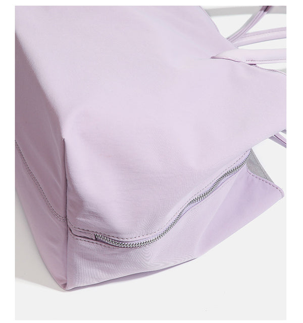 Large soft nylon tote bag with long double handles and zippered top in lavender, detail view 18