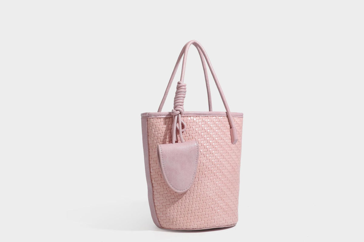 Structured woven-texture leather-look bucket bag in brown with knotted top handles, small front flap pouch, and adjustable