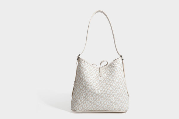 Woven geometric bucket shoulder bag in white and dark brown two-tone pattern with leather-look trim and drawstring top