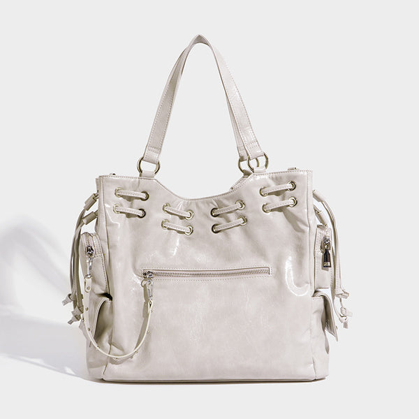 Glossy crinkled leather-look tote bag with silver grommet lace-up front detail, dual top handles, and detachable shoulder
