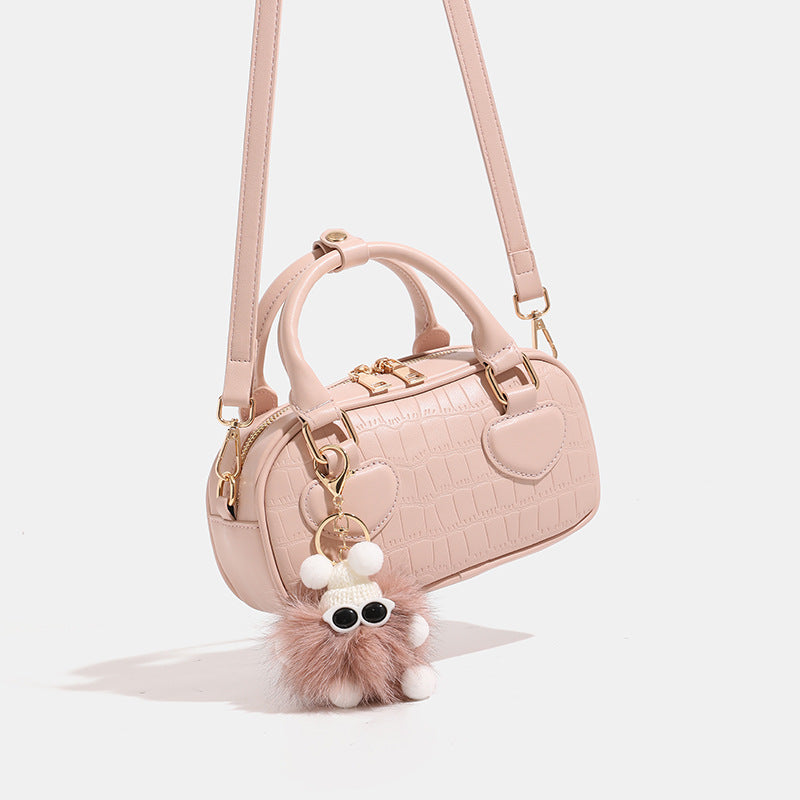 Mini croc-embossed barrel handbag with gold-tone hardware, dual zip top handles, detachable crossbody strap, and fluffy