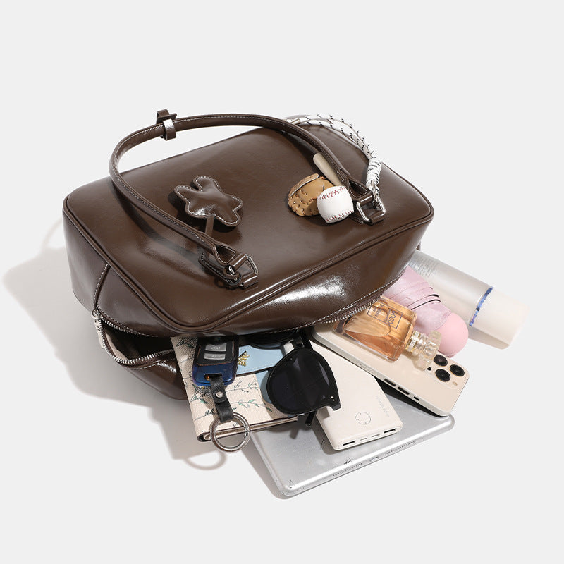 Große glänzende Boston-Tasche in Kunstlederoptik mit zwei Tragegriffen, Sternapplikation auf der Vorderseite und abnehmbarem Baseball-Anhänger-Set, Detailansicht