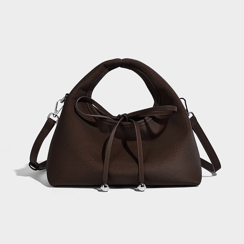 Pebbled matte trapezoid top-handle bag with drawstring bow closure, bead-tipped cords, silver-tone hardware, and detachable