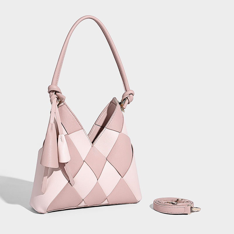 Compact bucket shoulder bag with black-and-white diamond patchwork panels, knotted top handle, gold-tone hardware, and