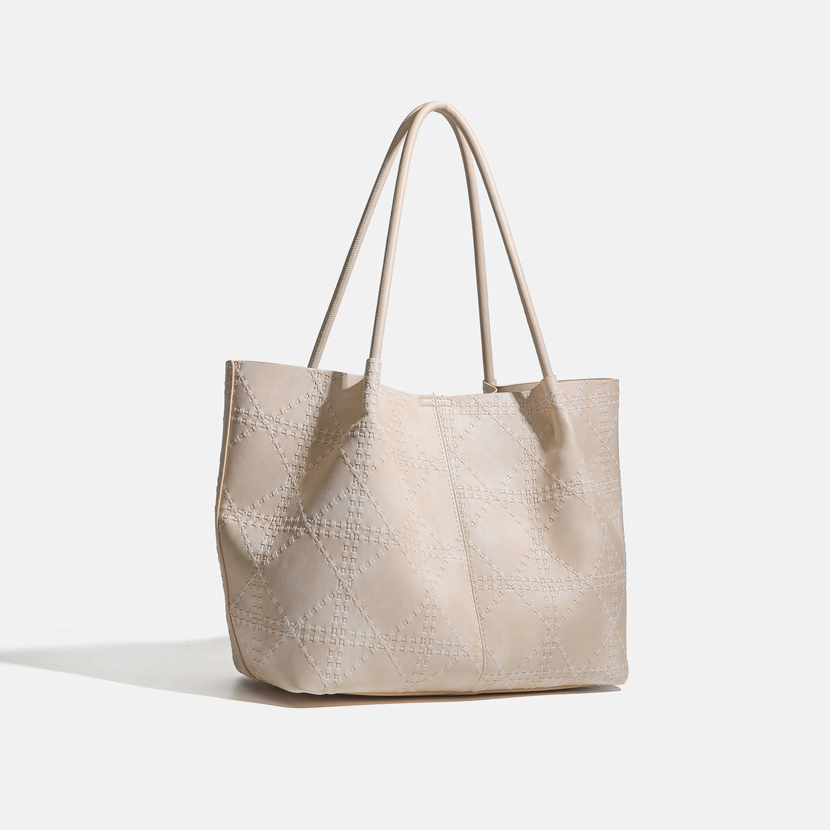 Large open-top tote bag with raised diamond-lattice stitching, long double shoulder handles, and gold-tone magnetic snap