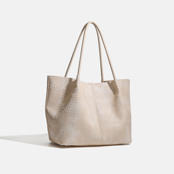 Large open-top tote bag with raised diamond-lattice stitching, long double shoulder handles, and gold-tone magnetic snap