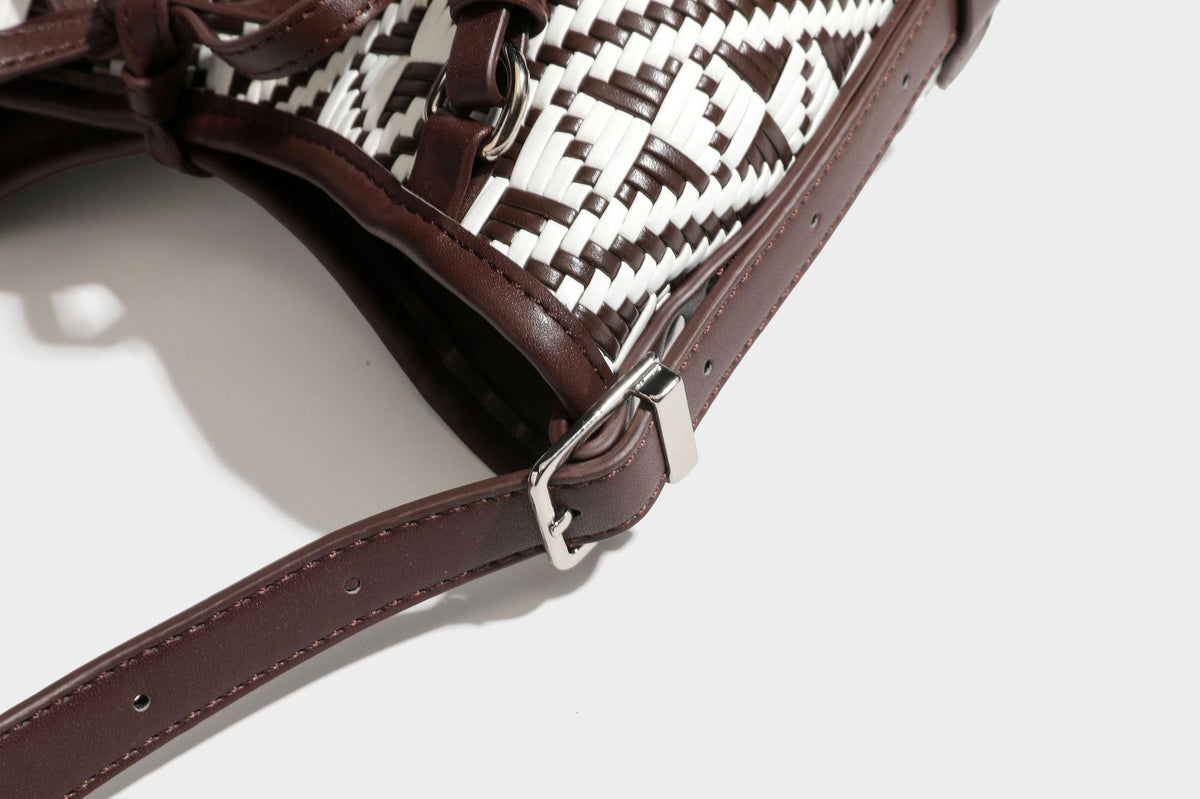 Woven geometric bucket shoulder bag in white and dark brown two-tone pattern with leather-look trim and drawstring top