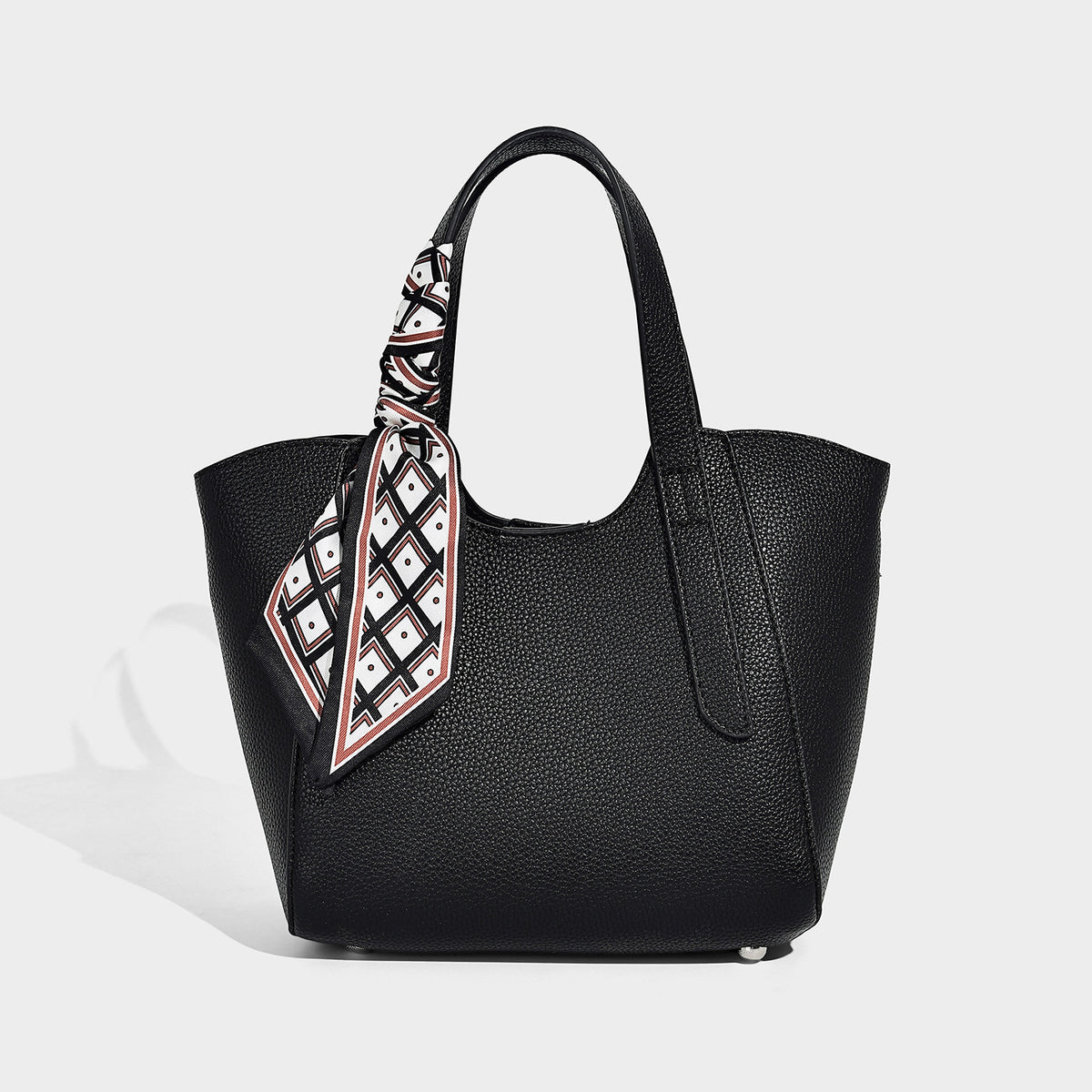 Structured pebbled leather-look tote bag with detachable scarf tie, dual top handles, and adjustable crossbody strap, detail