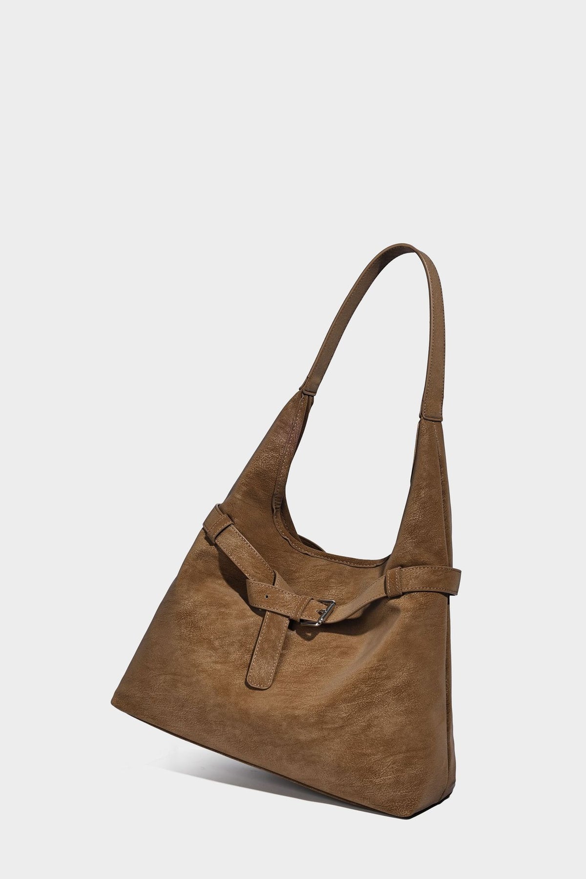 Slouchy oversized shoulder tote bag with matte textured finish, wrap-around buckle strap, and detachable front zip pouch