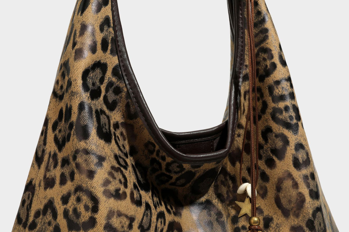 Weich fallende Hobo-Tote-Bag mit Leopardenmuster in Beige und Braun, dunkelbraunem Riemen in Lederoptik und herabhängenden Perlenanhänger-Beschlägen