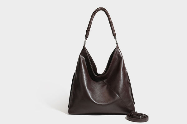 Large slouchy hobo shoulder bag with braided top handle, smooth glossy leather-look finish, and silver-tone ring hardware