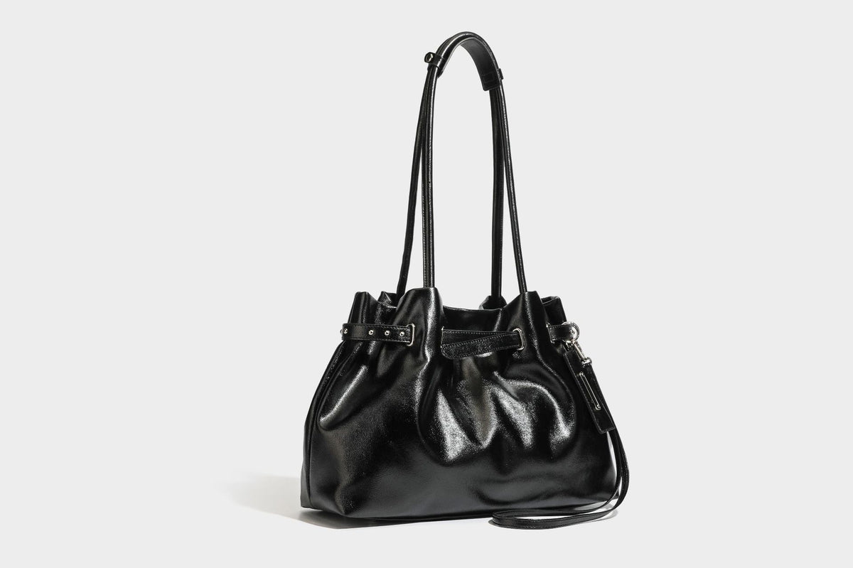 Glänzende schwarze, weich fallende Schultertasche mit gerafftem Abschluss, zwei langen Trageriemen, silberfarbenen Beschlägen und abnehmbarem Umhängeriemen