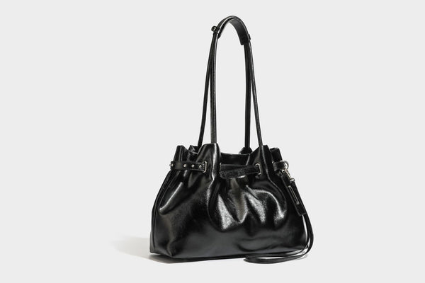Glänzende schwarze, weich fallende Schultertasche mit gerafftem Abschluss, zwei langen Trageriemen, silberfarbenen Beschlägen und abnehmbarem Umhängeriemen
