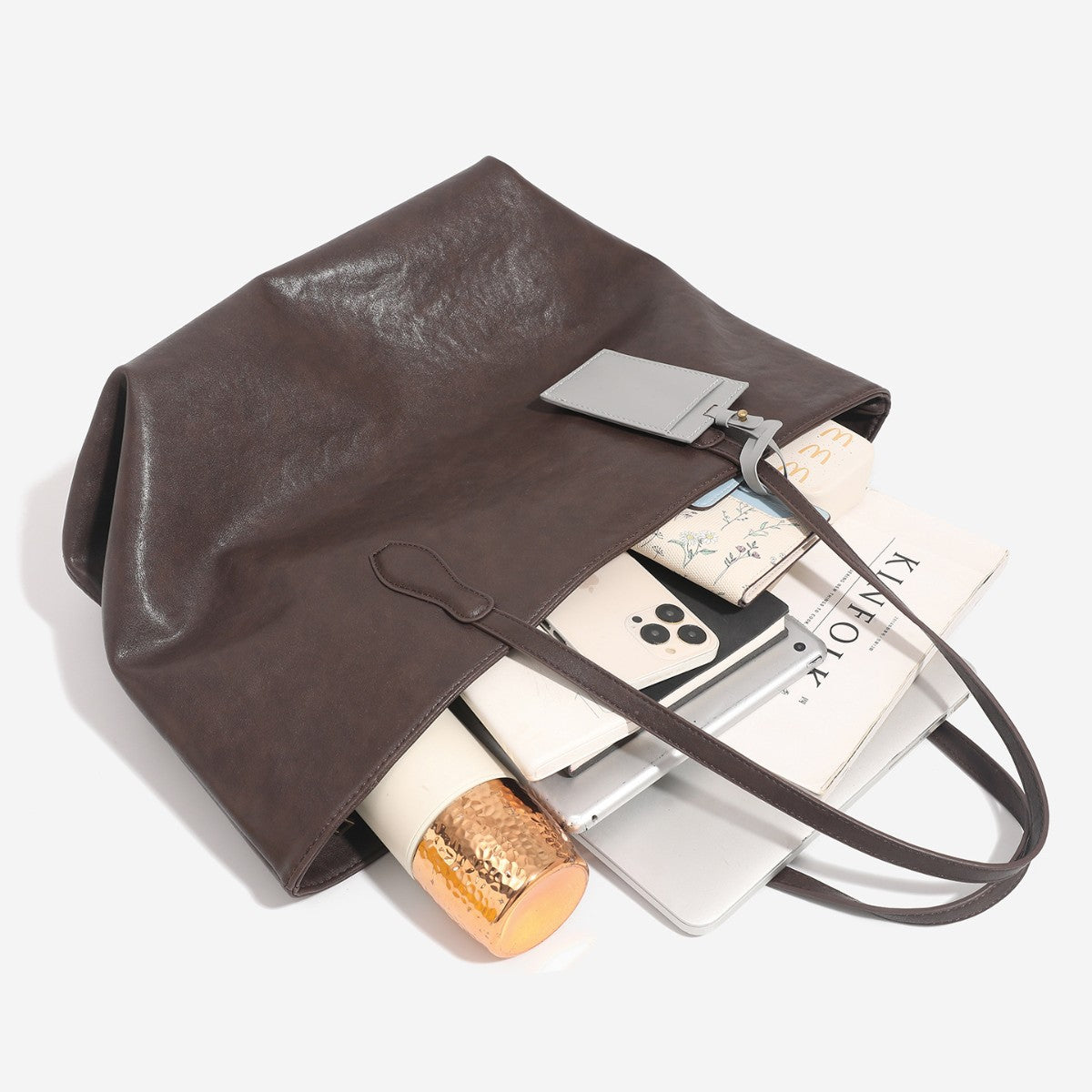 Large leather-look tote bag with trapezoid silhouette, double shoulder straps, and detachable hanging tag, detail view 4