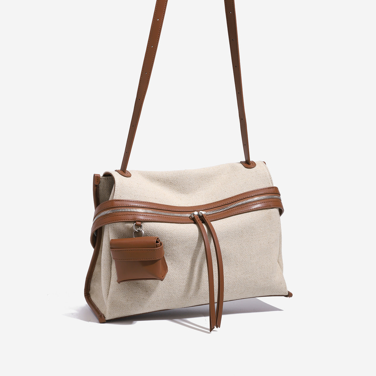 Cream canvas messenger shoulder bag with tan leather-look trim, dual zippers, tassel pulls, and attached mini front pouch