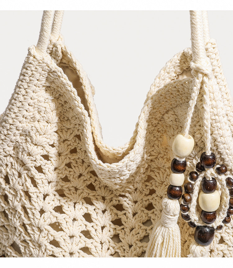 Cream openwork floral crochet tote bag with tassel and wooden bead charm and long rope shoulder straps, detail view 8