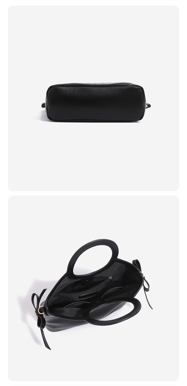 Structured trapezoid tote bag with oval top handle, glossy leather-look finish, side tie details, and gold-tone hardware