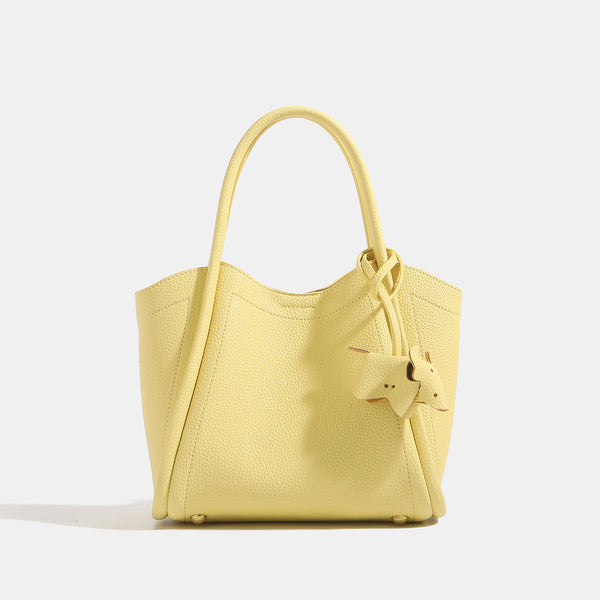 Small structured pebbled leather-look bucket tote bag with bow charm tie closure and gold-tone hardware, detail view 6