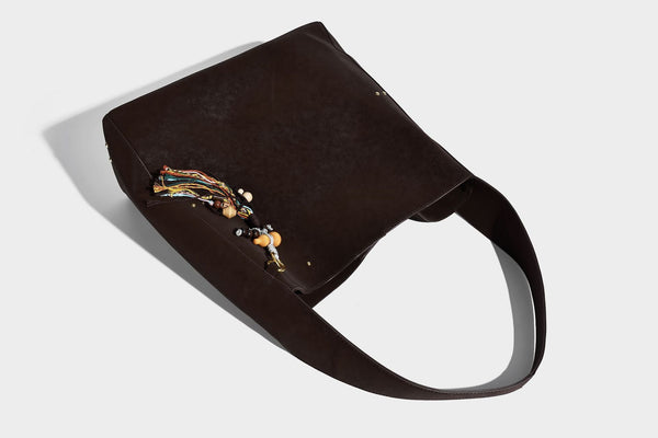 Oversized trapezoid tote bag with matte leather-look finish, gold-tone rivets, and long shoulder strap, detail view 18
