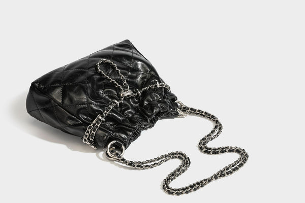 Glossy diamond-quilted drawstring bucket bag with silver chain shoulder strap and medallion charm, detail view 35
