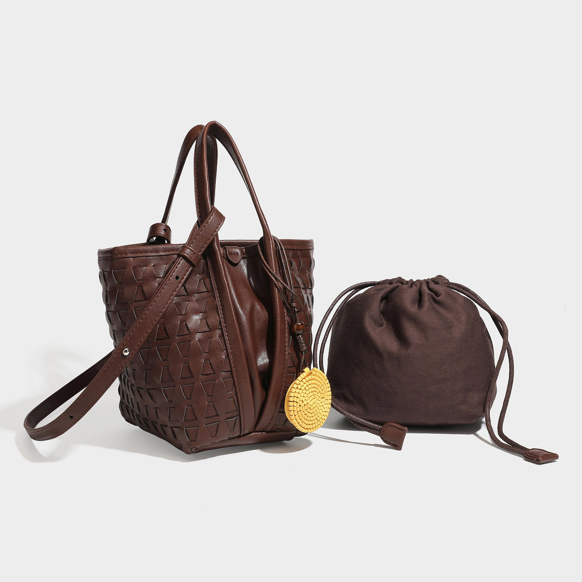 Small brown woven-texture bucket tote bag with drawstring closure, top handles, detachable shoulder strap, and round disc