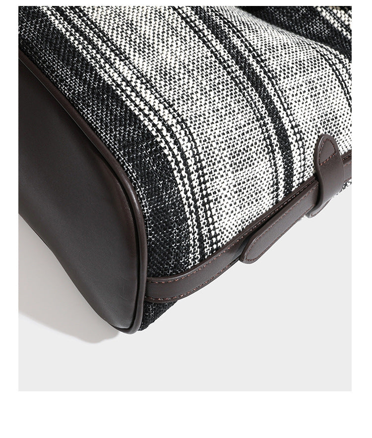 Schwarz-weiß karierte Hobo-Schultertasche aus gewebtem Material mit dunkelbrauner Einfassung in Lederoptik, Kordelzugverschluss und langem, verstellbarem