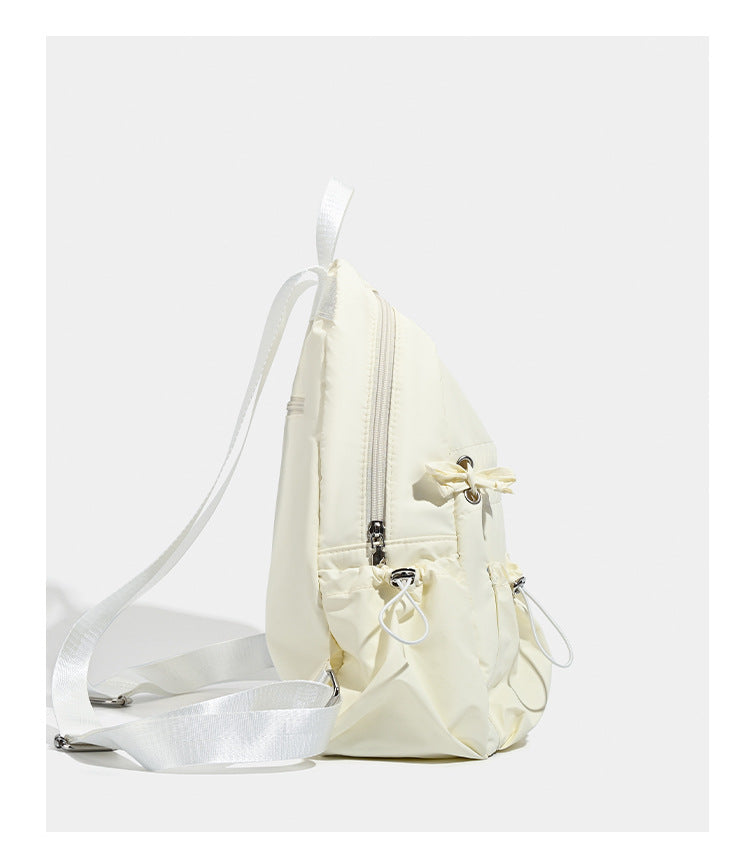 Puffy matte nylon mini backpack with drawcord gathered front pockets and silver-tone hardware, detail view 9