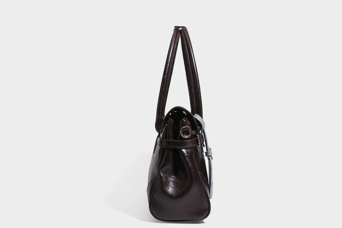 Structured glossy leather-look satchel bag with flap closure, gold-tone buckle accents, double top handles, detachable