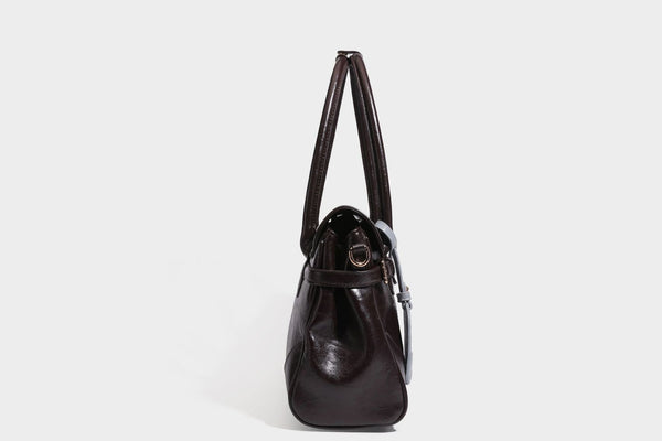 Structured glossy leather-look satchel bag with flap closure, gold-tone buckle accents, double top handles, detachable