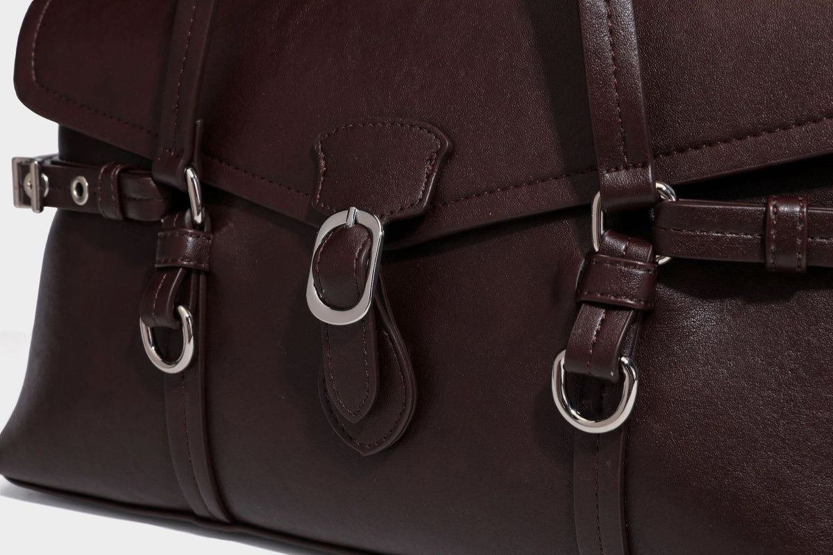 Strukturierte rechteckige Schultertasche mit Überschlagverschluss, vorderem Schnallengurt-Detail und ringförmigen Beschlägen in