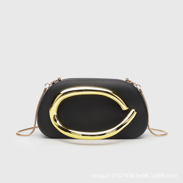 Kleine rechteckige Crossbody-Clutch mit abgerundeten Ecken, oversized poliertem C-förmigem Goldgriff und schmalem Goldkettenriemen, Detailansicht