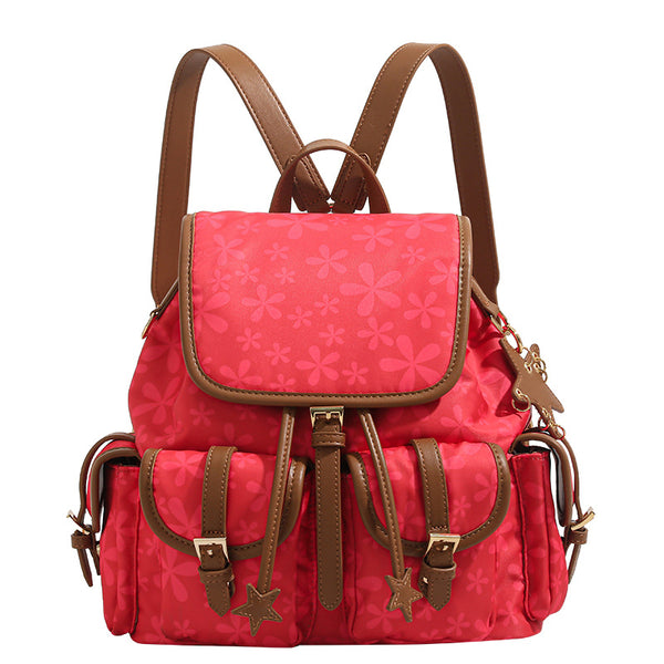 Red floral-print backpack handbag with brown leather-look trim, dual front buckle pockets, star charms, and gold-tone, detail