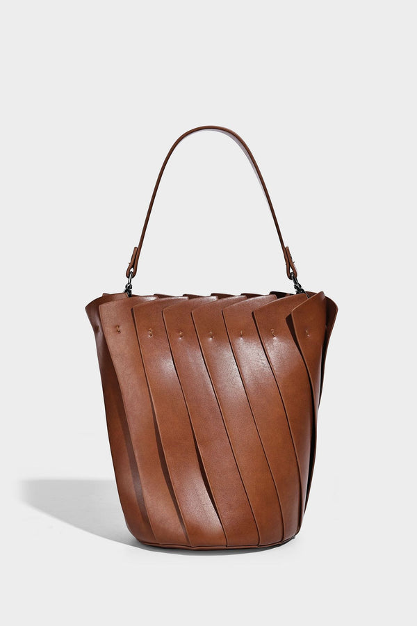 Structured pleated-panel bucket bag with curved top handle and detachable adjustable shoulder strap in smooth matte, detail