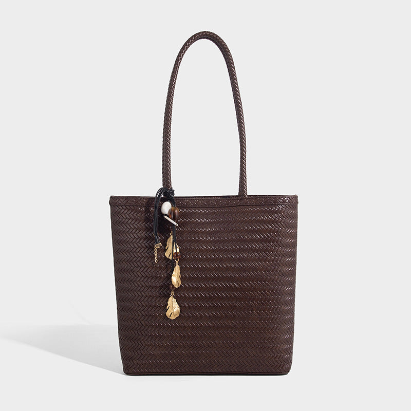 Structured woven herringbone tote bag with braided double shoulder handles in tan brown, shown with matching drawstring