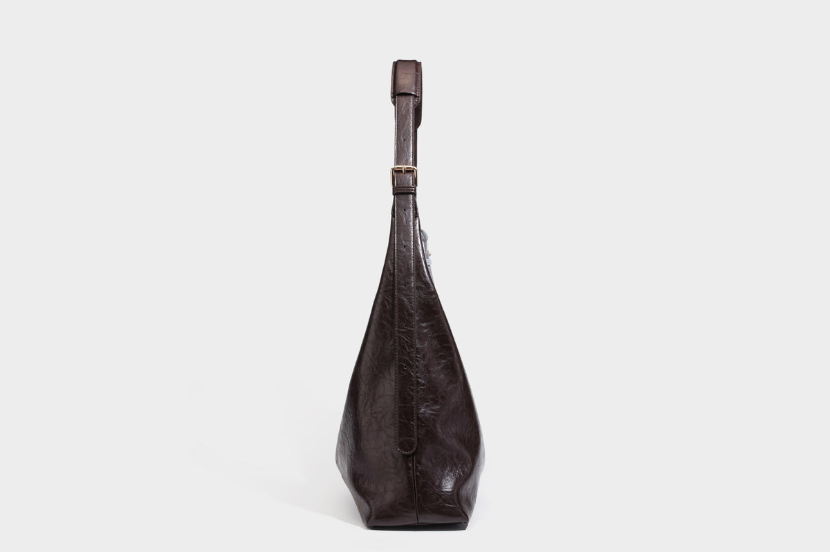 Große dunkelbraune, glänzende, geknautschte Hobo-Schultertasche mit Reißverschluss, goldfarbenen Metalldetails, verstellbarem Trageriemen und Hellblau
